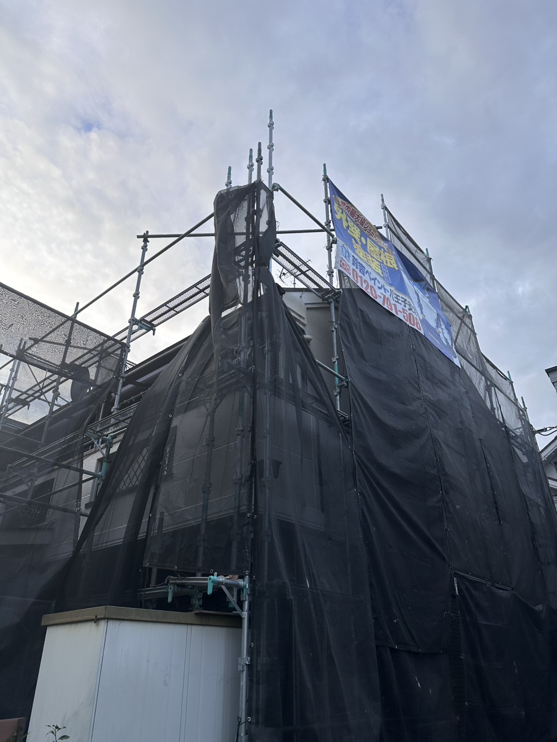 メッシュシートをたたんで足場へ固定した現場